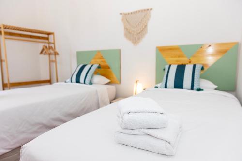 Duas camas com toalhas num quarto em Primera línea de playa Radazul em Radazul
