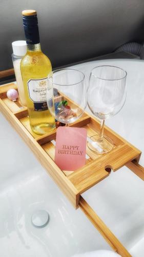 a wooden tray with two glasses and a bottle of wine at Dream Boutique Edam Coffee & Comfort in Edam