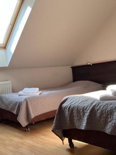 two beds in a room with a attic at Motel Orzeł in Szczecinek