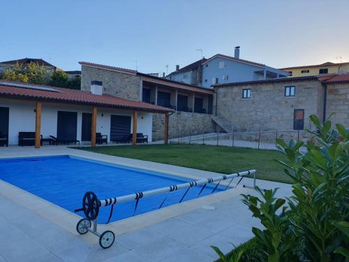 a swimming pool in the yard of a house at Casa da Marquinhas - Turismo Rural in Lama de Ouriço