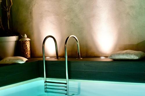 une baignoire avec deux robinets dans une salle de bain dans l'établissement La Maison Blanche 5*, Piscine & vue Cité Médiévale, à Carcassonne