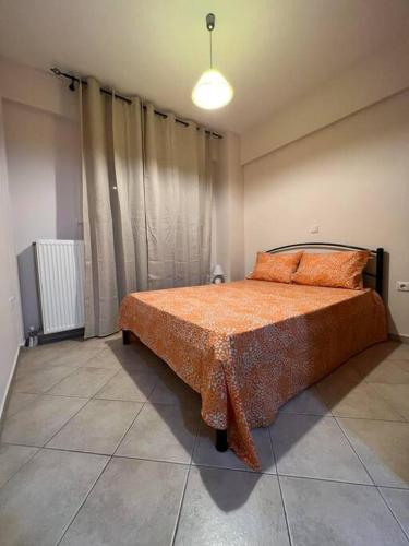 um quarto com uma cama com um edredão laranja em Αγρίνιο κέντρο ΔΣ A2 em Agrinio
