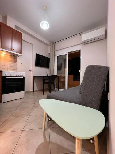 eine Küche und ein Wohnzimmer mit einem Tisch und Stühlen in der Unterkunft Αγρίνιο κέντρο ΔΣ A2 in Agrinio