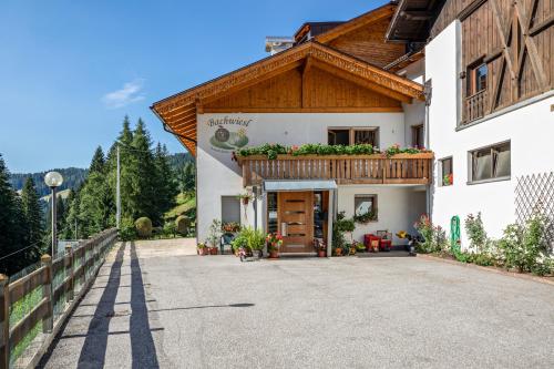 a large white building with a wooden roof at Bachwiesl Hof Apt Ocker in Proves
