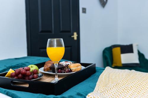 a tray of food and a glass of wine on a bed at Perfect for Long Stay Workers Leisure Families in Wolverhampton