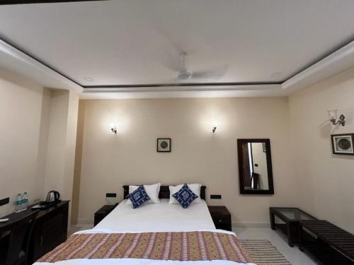 a bedroom with a large bed and a mirror at Hotel Desert Pride in Jaisalmer