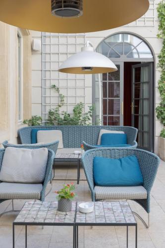 a patio with blue chairs and a table at Hotel Le Place d'Armes - Relais & Châteaux in Luxembourg