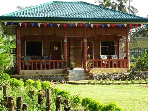 a small house with a porch and a fence at BregmanGuestHouse in Plaridel