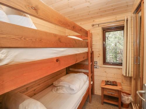 two bunk beds in a log cabin with a window at Canadian Cabin No 38 in Keswick