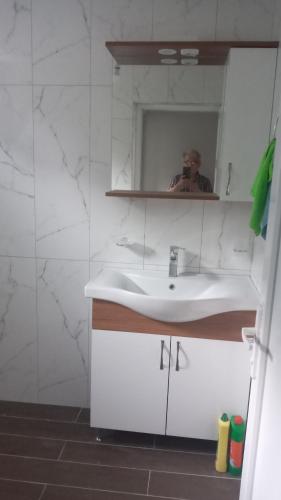 a man taking a picture of a bathroom with a sink at HAMSİKÖY cennet in Macka