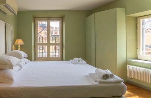 a large white bed in a room with two windows at EasyTopStay - Piazza Venezia Charming & Bright Apt in Rome