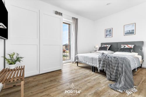 a white bedroom with two beds and a window at Ferienhaus Villa Dein Zuhause am Meer in Büsum