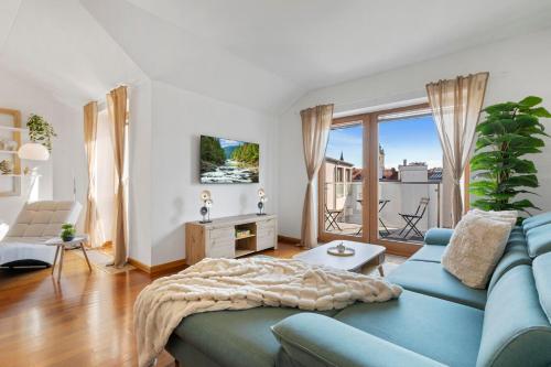 een woonkamer met een blauwe bank en een groot raam bij Urban Elegance Retreat in Bratislava