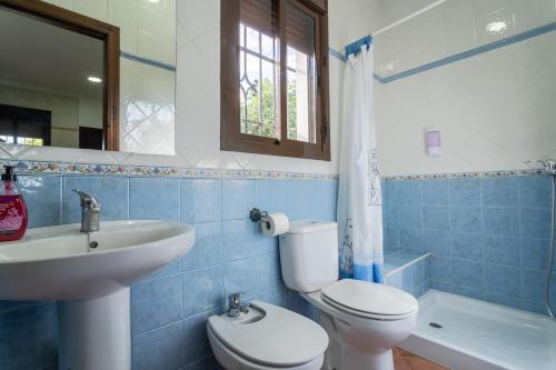een badkamer met een wit toilet en een wastafel bij EntreCalas 1 Chalet con jacuzzi en Conil, Roche viejo, cala del aceite in Conil de la Frontera