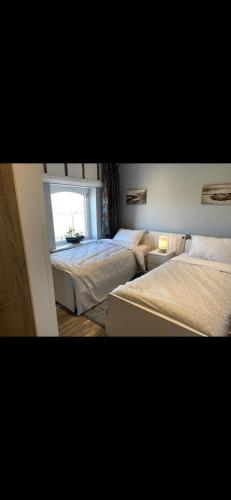 1 dormitorio con 2 camas y ventana en The Lifeboat & Seaview Terrace, en Skerries