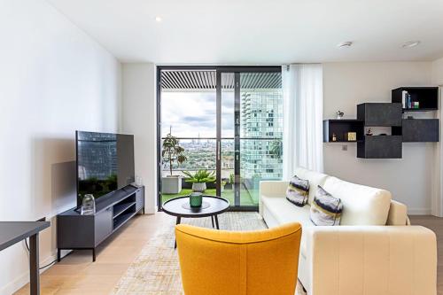a living room with a couch and a tv at Canary Wharf City Escape 1-Bed Apartment in London