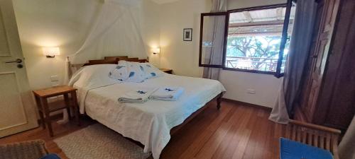 1 dormitorio con 1 cama con sábanas blancas y ventana en Clair de Lune - Private 2 Bedrooms Beachfront Villa, en Trou d'Eau Douce