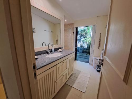 La salle de bains est pourvue d'un lavabo et d'un miroir. dans l'établissement Clair de Lune - Private 2 Bedrooms Beachfront Villa, à Trou dʼ Eau Douce