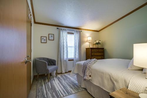 een slaapkamer met een bed, een stoel en een raam bij Tranquil Dutch Country Home 2 Decks, Farm Views! 