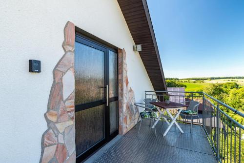 a balcony with a door and a table and chairs at Hügelblick Oase in Kraichtal