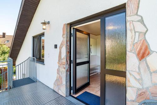 a glass door on a house with a stone wall at Hügelblick Oase in Kraichtal