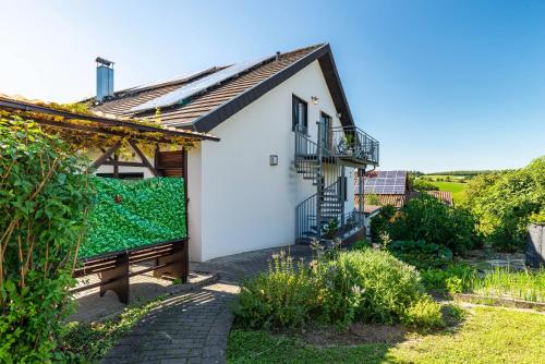 a white house with a balcony and a garden at Hügelblick Oase in Kraichtal