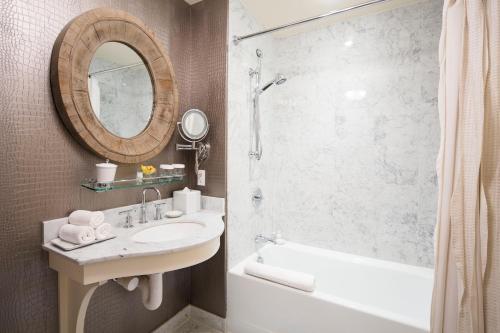a bathroom with a sink and a shower and a mirror at Delamar Southport in Southport