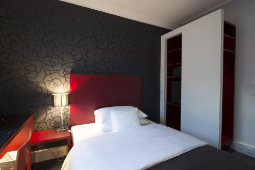 a bedroom with a white bed and a red wall at Hotel Mon Repos in Geneva