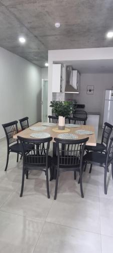 uma sala de jantar com mesa e cadeiras e uma cozinha em Tranquilo dpto. zona aeropuerto!!! em La Mercedes