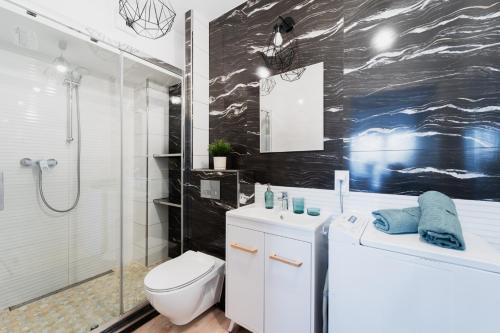 ein Bad mit einer Dusche, einem WC und einem Waschbecken in der Unterkunft Apartment OLD TOWN - 3 Rooms - 2 Bathrooms - 12 People - Parking Place in Breslau