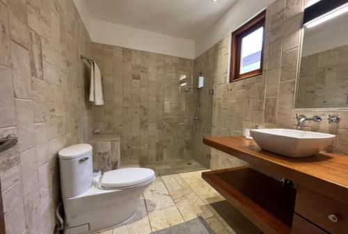 a bathroom with a white toilet and a sink at Sunny Vacation Villa NO 87 in San Rafael del Yuma
