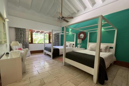 a bedroom with two beds in a room with green walls at Sunny Vacation Villa NO 87 in San Rafael del Yuma