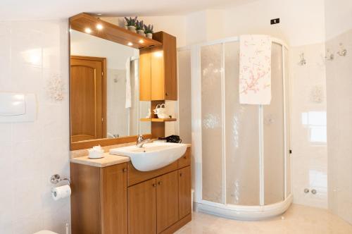 La salle de bains est pourvue d'un lavabo et d'une douche. dans l'établissement B&B La Bouganville, à Vigolo