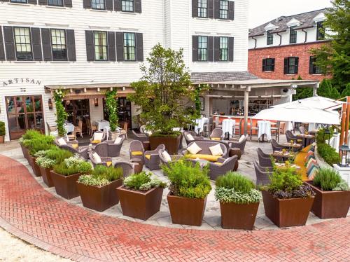 a patio with chairs and plants in front of a building at Delamar Southport in Southport