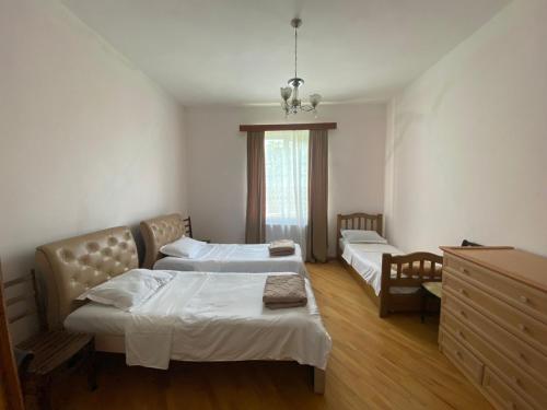 a bedroom with two beds and a dresser in it at Family Guest House Marso in Ssatschcheri