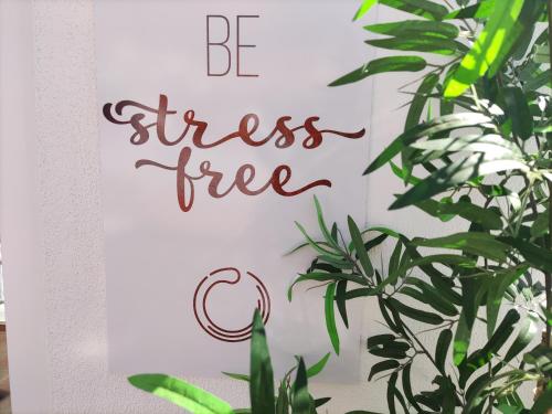 a sign that reads be stress free next to a plant at stressfree charm house in Odeceixe