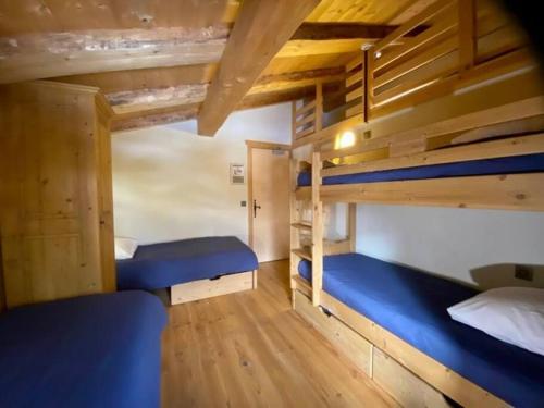 two bunk beds in a room with wooden ceilings at Gîte La Loriaz in Vallorcine