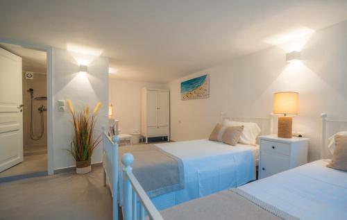 プラティスヤロス・シフノスにあるVilla Glarosの白いベッドルーム(ベッド2台付)、廊下が備わります。