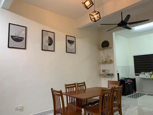 a dining room with a wooden table and chairs at Juwita&Arjuna Homestay Teluk Senangin 