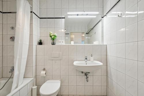 y baño con lavabo, aseo y espejo. en Charming 60m² with King Bed, Kitchen, Netflix and Workspace with 1000 Mbit/s, en Wiesbaden