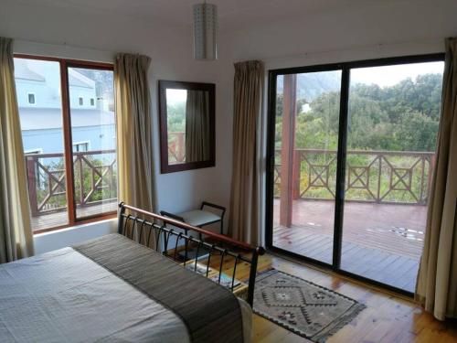 a bedroom with a bed and a view of a deck at Paradise Beach House in Clareport