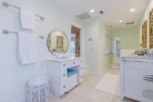 Baño blanco con lavabo y espejo en Indian Harbor Haven en Vero Beach