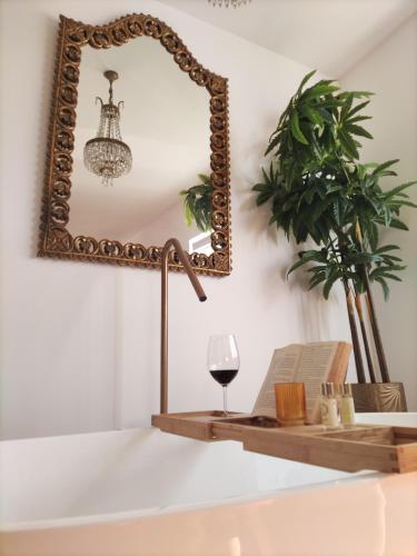 a mirror and a table with a glass of wine at stressfree charm house in Odeceixe