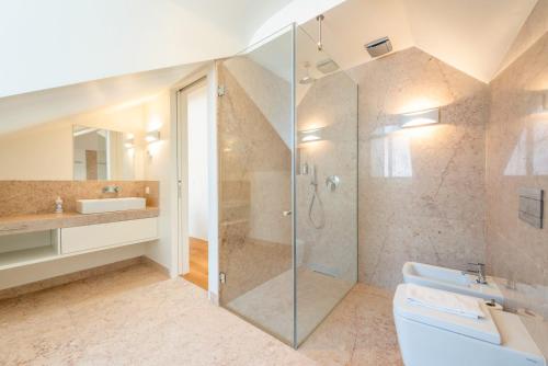 a bathroom with a shower and a toilet and a sink at GuestReady - Conde das Alcáçovas in Paço de Arcos