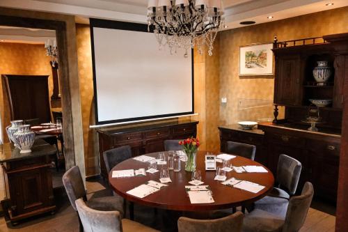a dining room with a table and a projection screen at Platan Udvarhaz in Tata