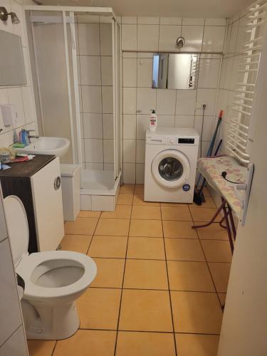 a bathroom with a toilet and a washing machine at Grzegorzecka Room nr 2 in Krakow