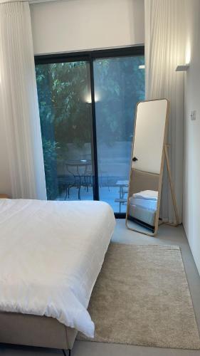 een slaapkamer met een bed en een stoel voor een raam bij סוויטה פרטית ברמת צבי in Temarah