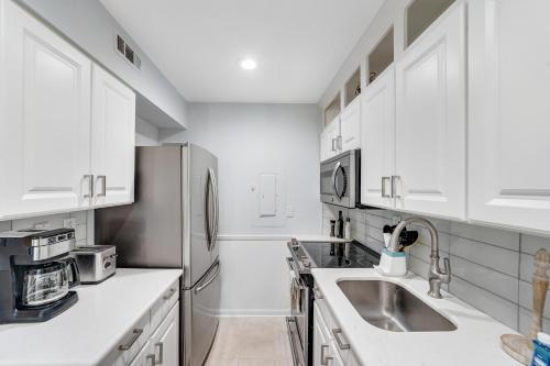 a kitchen with white cabinets and a sink at Sea Colony---1805 Doubles Court in Bethany Beach
