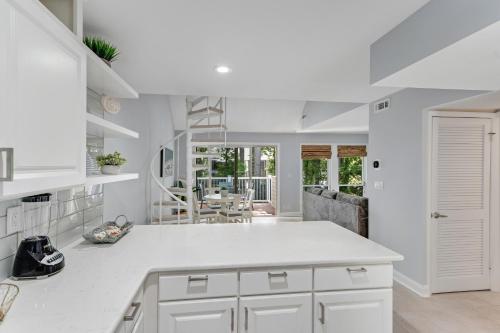a kitchen with white cabinets and a dining room at Sea Colony---1805 Doubles Court in Bethany Beach
