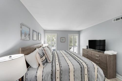 a white bedroom with a bed and a tv at Sea Colony---1805 Doubles Court in Bethany Beach